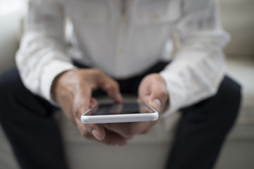 Businessman is using a smart phone on the sofa