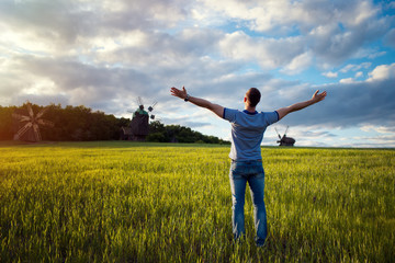 Fototapeta na wymiar Man on nature background with arms outstretched. Free man