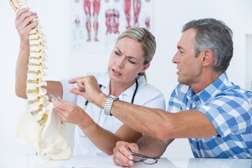 Doctor showing her patient a spine model