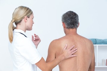 Doctor examining her patient back 