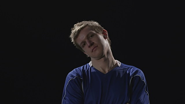 A soccer player looks into the camera intensely