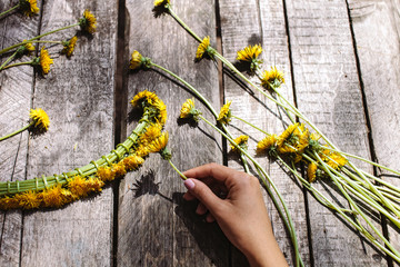 wreath of dandelions flowers handmade on wood table