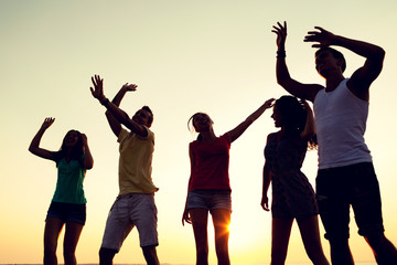 Fototapeta premium smiling friends dancing on summer beach