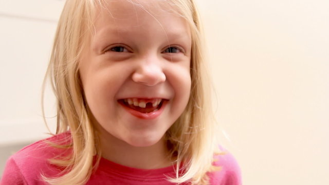 Cute little girl shows off her tooth to the camera