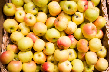 ripe apples in basket at food market or farm