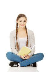 Teen woman sitting with her notebook.