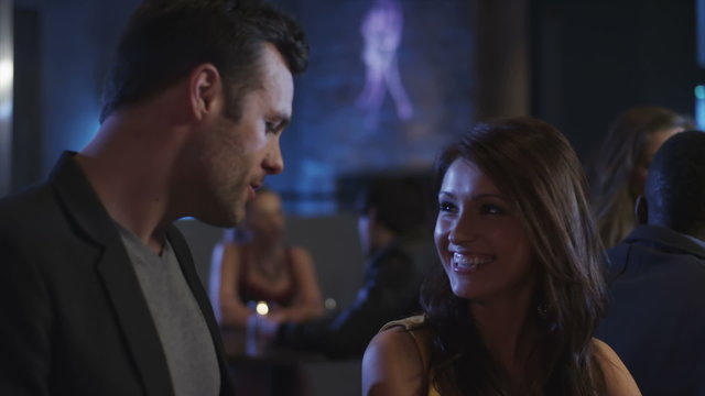 A couple at a bar flirt with each other 