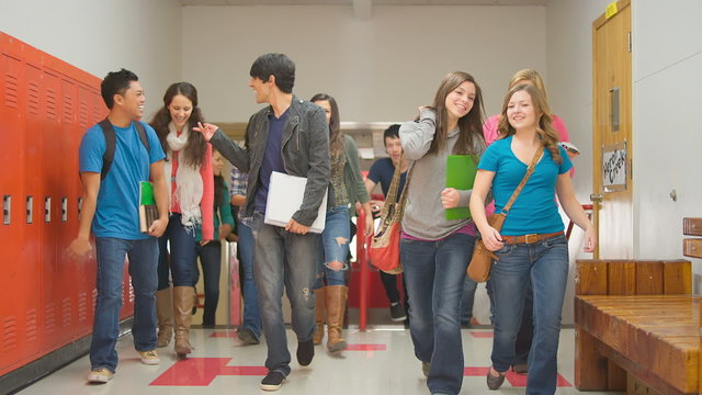 A group of students walk up the stairs and down the hallway