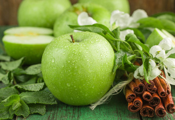 Green apples, mint and cinnamon on the table