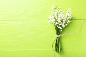 Lily of the Valley on green wooden background - obrazy, fototapety, plakaty