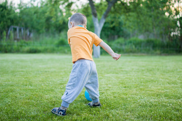 boy playing football on the green grass with ball
