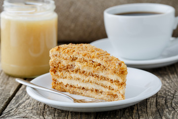 Tasty honey cake with jar of honey.