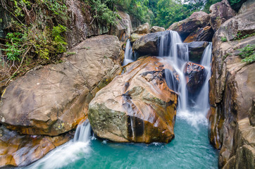 Jungle waterfall with flowing water, large rocks © Biskariot