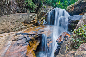 Jungle waterfall with flowing water, large rocks © Biskariot