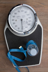 In a bathroom a scale under wooden background