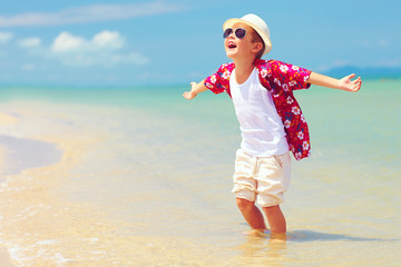 happy fashionable kid boy enjoys life on summer beach © Olesia Bilkei