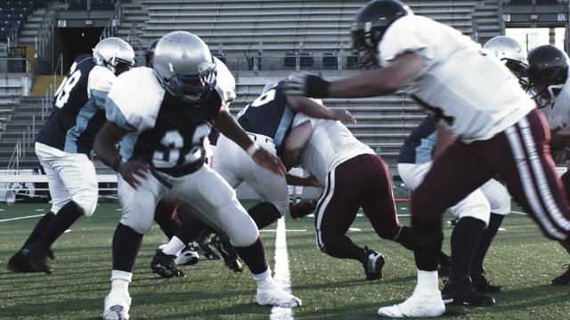 A football player runs through the line and avoids tackles