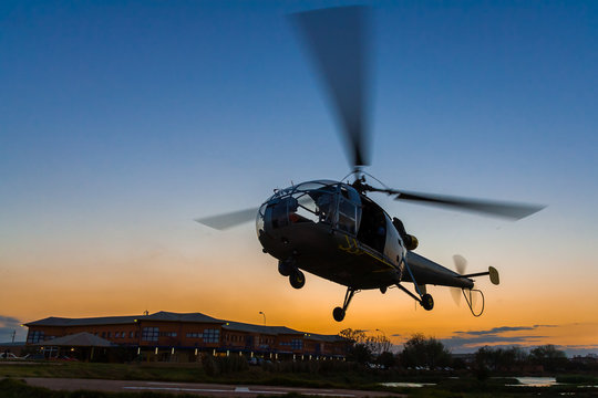 Helicopter landing at sunset to the heliport