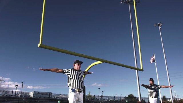 Two referees wave their arms back and forth after a missed field goal