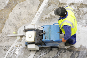 worker using cutting  pavement machine in the city road