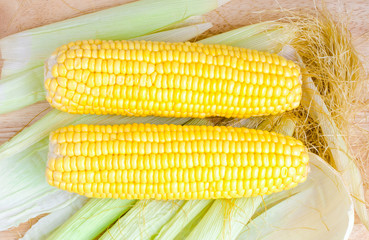 Sweetcorns and cob on wooden table