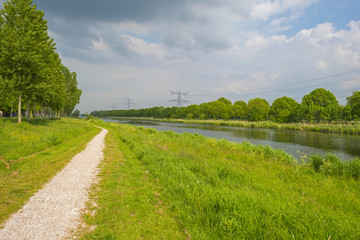 Footpath along the shore of a canal in spring