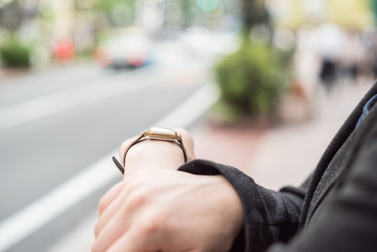 街中で腕時計を確認する女性の手