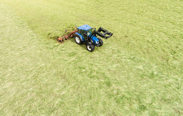 Heuernte, Traktor mit Heumaschine von oben, Luftbild