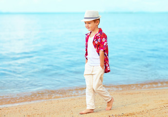 handsome fashionable kid, boy walking on sandy beach