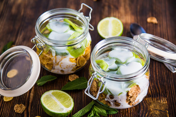 Wheat and corn flakes with yogurt and kiwi in the jar