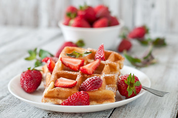 Belgium waffles with strawberries and mint on white plate - obrazy, fototapety, plakaty