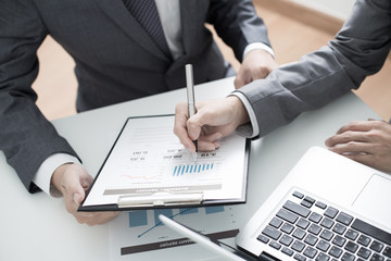 Two businessmen looking at report and having a discussion in off