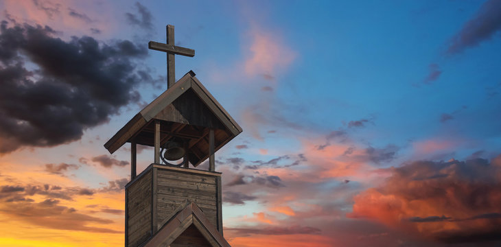 A Bell Tower with Cross at Sunset