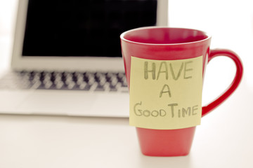 Note and post-it on cup of coffee with laptop