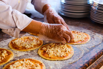 Obraz na płótnie Canvas The chef, who puts toppings on a pizza