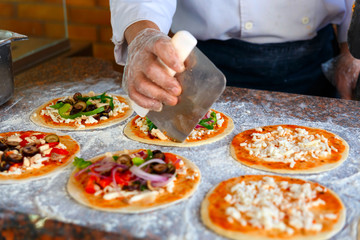 The chef, who puts toppings on a pizza