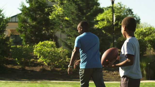 A father high fives his son, playing football