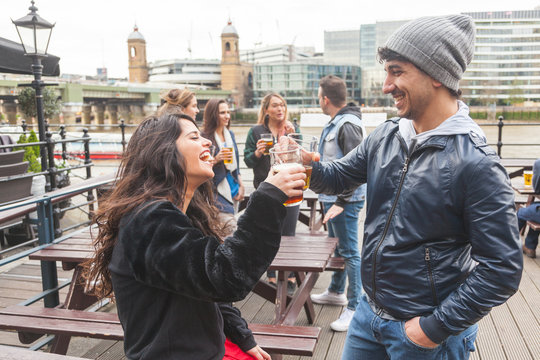 Young couple enjoying a beer at pub in London.