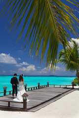 Coppia di sposi con mare turchese.