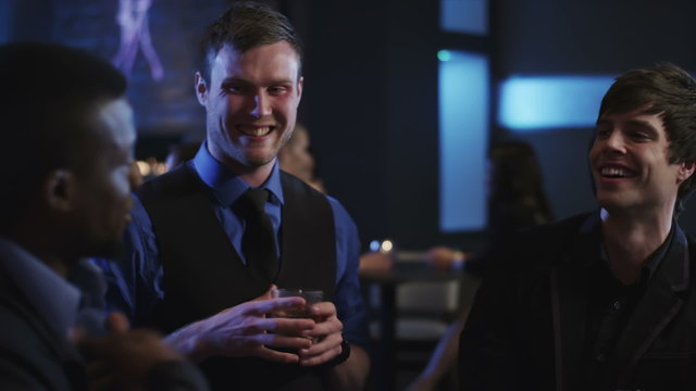 young men talking at the bar having a drinks and checking out the women