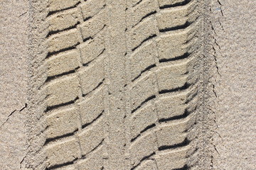 An oblique tire pattern in yellow sand
