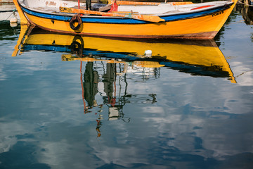 Fototapeta na wymiar Reflection of the yellow boat.