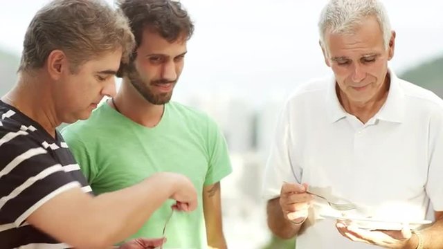 Men entertaining a baby at a Brazilian family BBQ