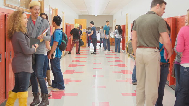 Students talk to each other while standing in the hallway before the next class
