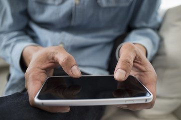 Men have a cell phone sitting on the sofa