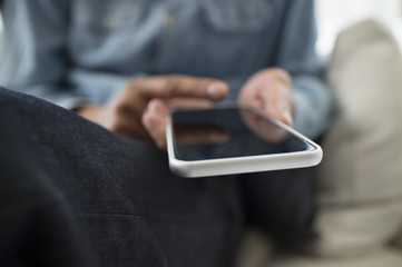 Men have a cell phone sitting on the sofa