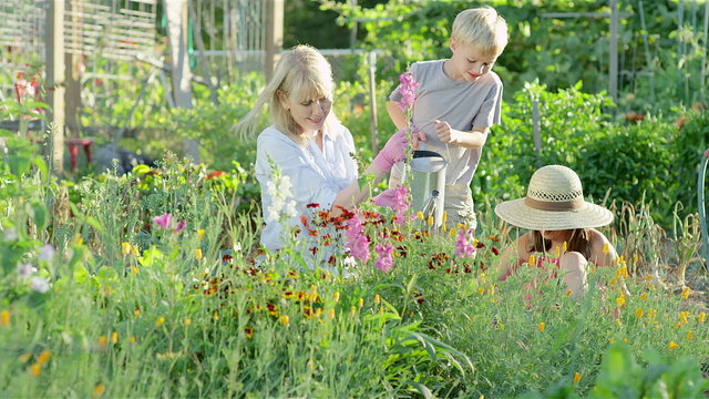 kids get a lesson in gardening by their grandmother on a beautiful spring day