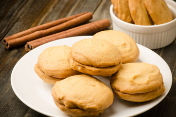 Homemade cookies on white plate and wooden background