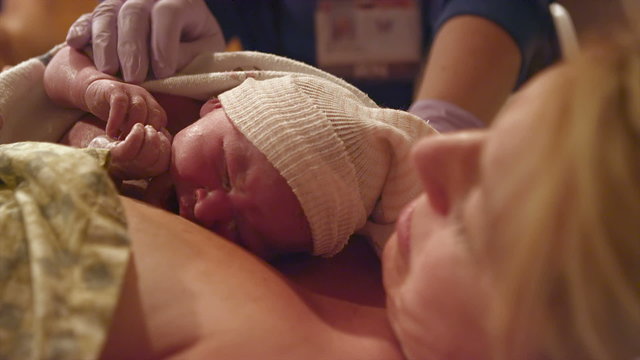 A newborn baby born just minutes before gets a hat on to stay warm