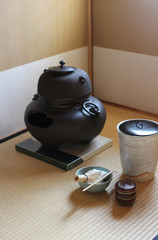 日本の茶室の中で畳の上に置いてある茶釜と茶道具